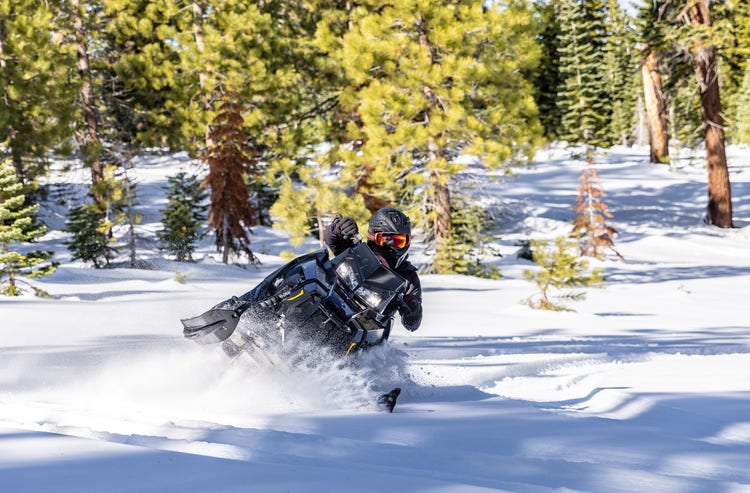 Man crashing through snow on a snowmobile